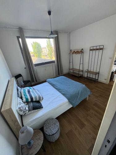 里尔Rijsel Vlamse的一间卧室配有一张床,窗户配有两把椅子
