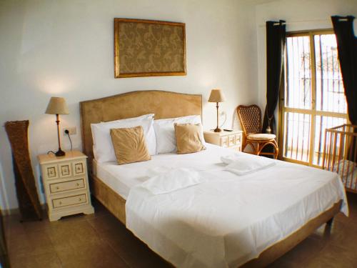 Las Lagunas MijasCasa Ladera的卧室设有一张白色大床和一扇窗户。