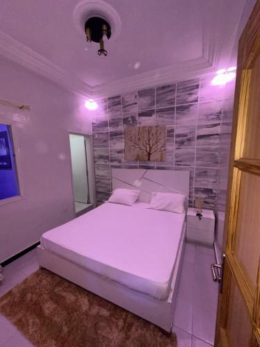 达喀尔Welltima Teranga的卧室配有白色的床和墙壁