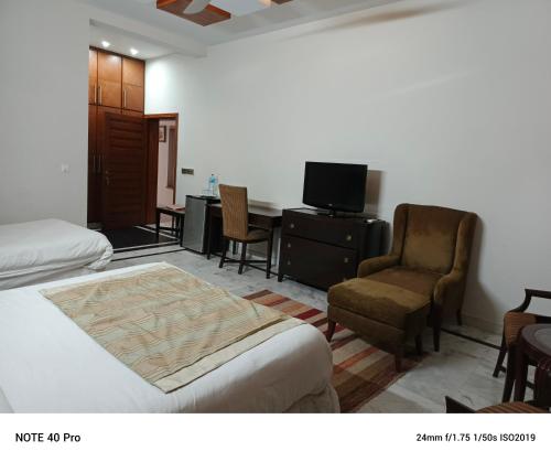 伊斯兰堡Palladium Executive的酒店客房配有一张床、一把椅子和一张书桌