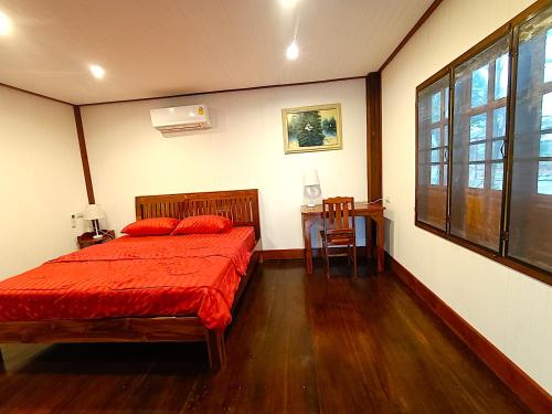 黎逸府Isaan Perazim Park的一间卧室配有一张床、一张桌子和一个窗户。