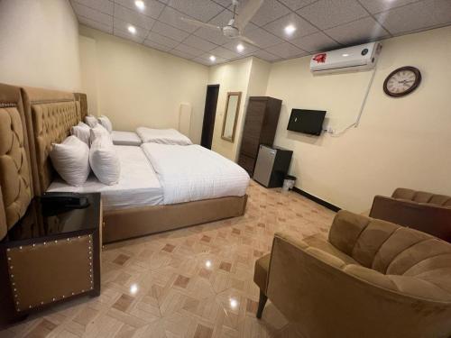 伊斯兰堡Cozy Cottage Islamabad的一间卧室配有一张床、一张沙发和一台电视。