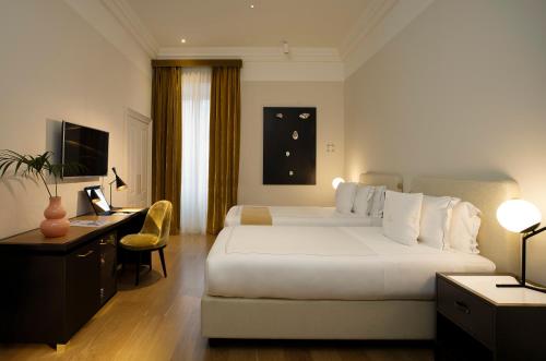 罗马伊丽莎白独特酒店|设计酒店™成员的酒店客房设有一张大床和一张书桌。