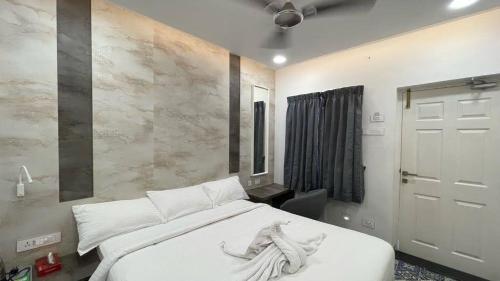 杜蒂戈林Mayilveedu Guest House的卧室配有白色床单和白色大床