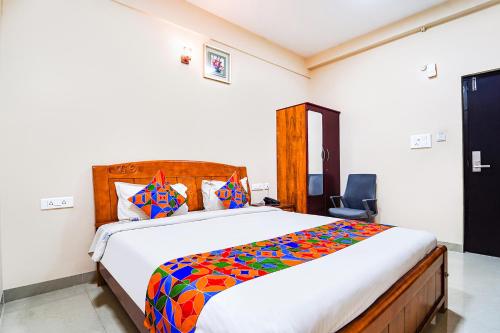IrugūrFabExpress UV Residency的一间卧室配有一张大床和色彩缤纷的被子