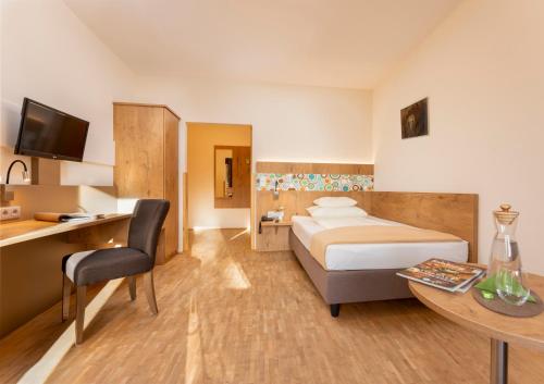 萨尔茨堡海夫特豪夫酒店的配有一张床、一张桌子和一张桌子的酒店客房