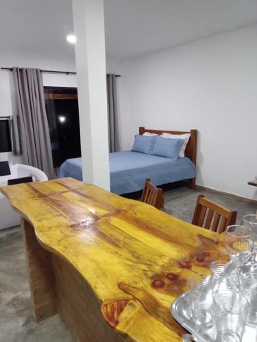 圣托梅-达斯莱特拉斯Chales Paraíso STL的一张木桌,位于带一张床的房间里