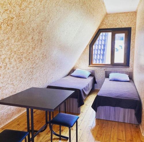 ZhanalykЯхта的客房设有两张床、一张桌子和一扇窗户。