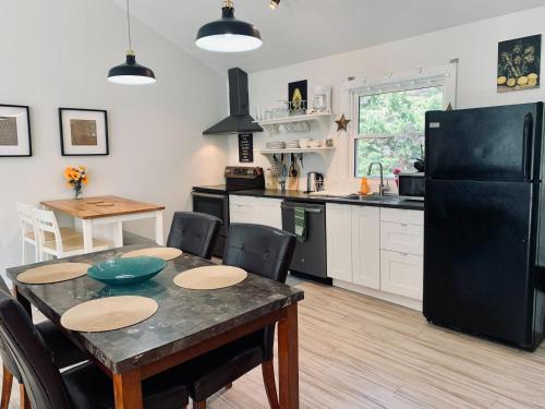 哈利法克斯Serene Cottage的厨房配有桌子和黑冰箱。