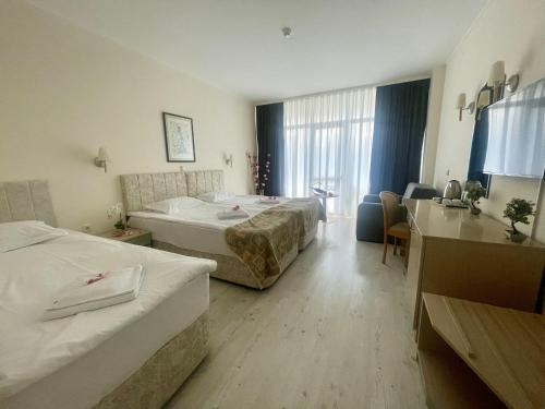 阳光海滩Grand Hotel Nirvana - All Inclusive & Free Beach Access的酒店客房配有两张床和一张书桌