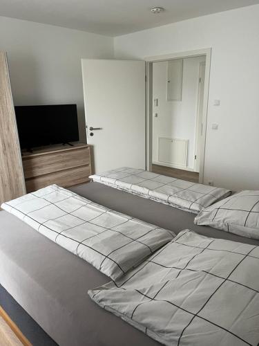 博登湖畔克雷斯波洛Ferienwohnung am Yachthafen的客房设有两张床和一台平面电视。