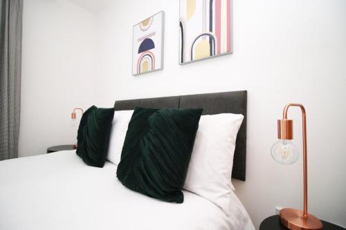 卡迪夫Quaysideone bedroom apartment in Cardiff Bay的一间卧室配有带绿色和白色枕头的床