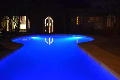 圣佩德罗·德·阿塔卡马阿尔迪酒店的夜晚在院子里有一个灯光蓝色的游泳池
