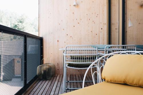 菲希塔赫Adventure Camp Schnitzmühle的木制甲板上配有桌椅的阳台
