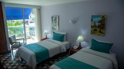卡塔赫纳Hotel Bahia Cartagena的酒店客房设有两张床和窗户。