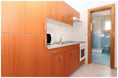 普利莫顿M&Z Apartmani的一个带木制橱柜和水槽的厨房