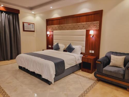 吉达الديار الفاخرة - الربوة的一间卧室配有一张大床和一把椅子
