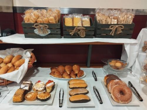 坎加斯-德奥尼斯坎加斯奥尼斯城酒店的一张桌子,上面放着许多不同类型的糕点和面包