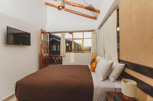 乌鲁班巴Kutimuy Lodge的一间卧室配有一张大床和电视