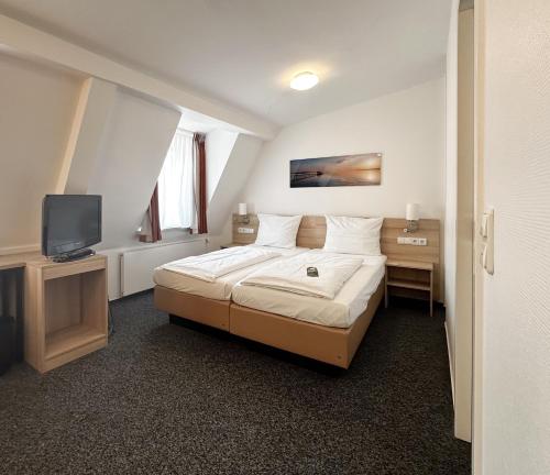基尔柏林霍夫酒店的酒店客房,配有床和电视