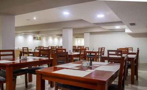 圣玛尔塔圣玛尔塔里拜酒店的用餐室配有木桌和椅子