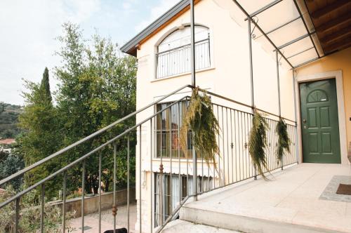 维罗纳Casale Manzoni的一座带绿门和阳台的房子