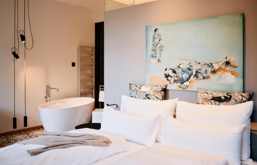圣沃尔夫冈兰德豪斯祖阿佩巴奇酒店的卧室配有白色枕头和浴缸