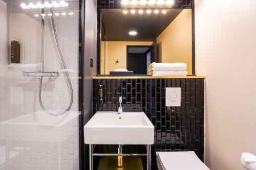 马恩河畔博纳伊克雷泰伊马恩河畔波涅基里亚德酒店的一间带水槽、淋浴和镜子的浴室