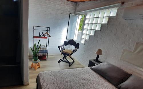 梅塞德斯Confortable apartamento-monoambiente en Mercedes的卧室配有床、椅子和窗户。