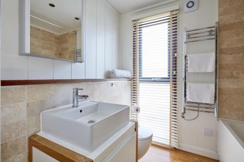 贝克因顿Farleigh Lodge的白色的浴室设有水槽和卫生间。