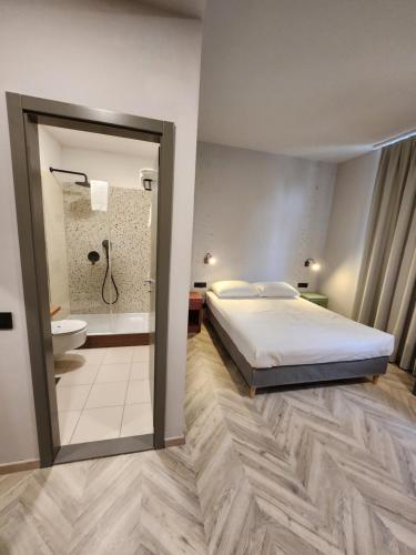 普拉阿姆费提塔酒店的一间卧室配有一张床,浴室设有淋浴。