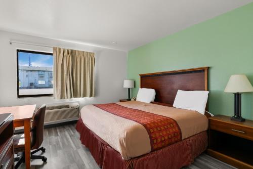 林垦美国最佳价值汽车旅馆 - 林肯机场的配有一张床、一张书桌和一扇窗户的酒店客房