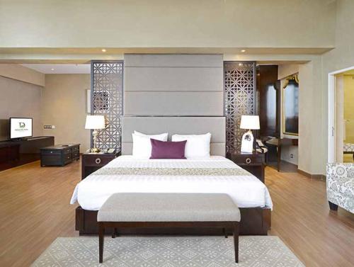 LukunyuLoginecoresort的大卧室配有一张带紫色枕头的大床