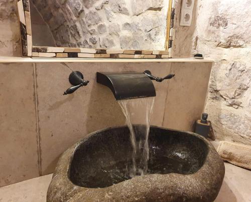 VászolyTraditional cottage at Lake Balaton的浴室设有水槽,水倒入其中