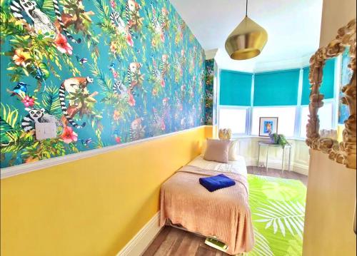 伯恩茅斯Yellow Lemur Apartment - Lemur Lodge - Short Stroll to the Beach - Free Wifi的一间卧室设有黄色墙壁和彩色壁画