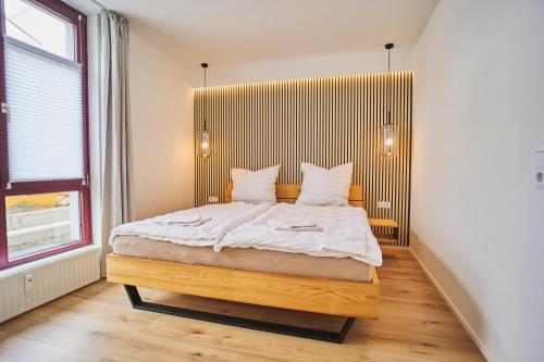 布伦瑞克City-Deluxe in Braunschweig的一间卧室配有一张大床和木制床头板
