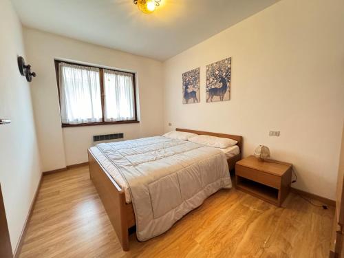 GiustinoAppartamenti Doss的一间卧室设有一张大床,铺有木地板