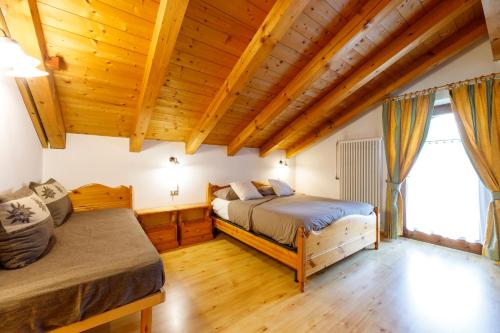 卡瓦莱塞B&B Seppi的配有木天花板的客房设有两张床。