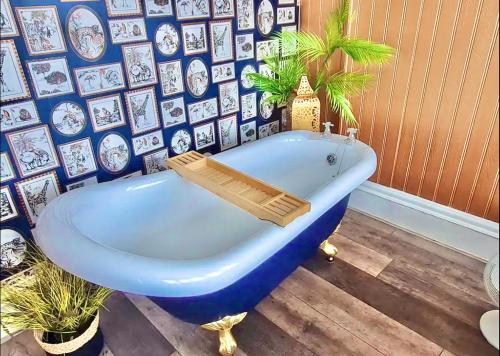 伯恩茅斯Blue Cheetah Lemur Lodge的一张蓝色浴缸,位于一个有画墙的房间