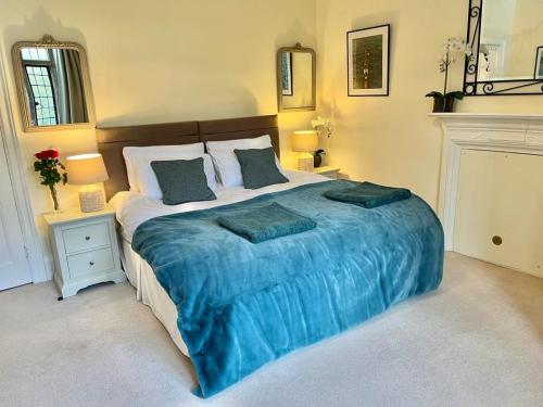 Great BadmintonParsonage House, Badminton的一间卧室配有一张带蓝色毯子的大床