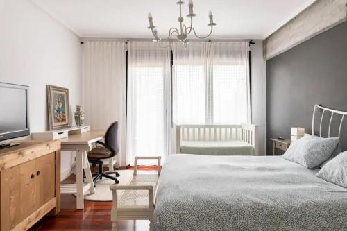 莱萨马Karaltzos LB00530的一间卧室配有一张床、一张书桌和一台电视
