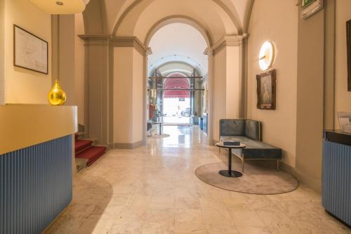 古比奥博索尼宫殿酒店的大楼内带椅子和桌子的走廊