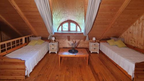 VászolyTraditional cottage at Lake Balaton的小屋内带两张床和一张桌子的房间
