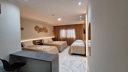 马拉戈日Pousada Marítimos的酒店客房设有两张床和电视。