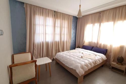 马拉喀什Belle Villa duplex avec piscine的一间卧室设有一张床和一个大窗户