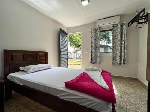 伊瓜苏Pousada Cidade Linda的一间卧室配有一张床铺,床上铺有红色毯子