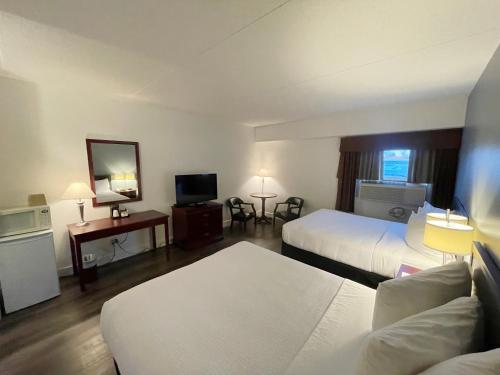 卡姆罗斯Days Inn & Conference Centre by Wyndham Camrose Norsemen的酒店客房设有两张床和电视。