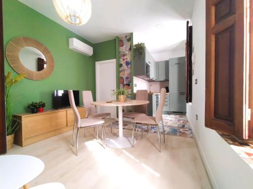 曼萨纳雷斯Casa Rístori Fábrica de Harinas的一间拥有绿色墙壁和桌椅的用餐室