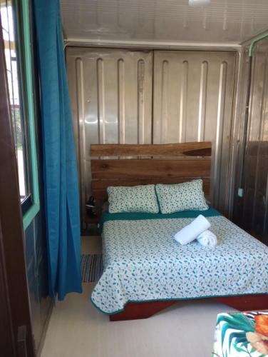 卡维塔Container House Cahuita的一间卧室配有床和蓝色窗帘
