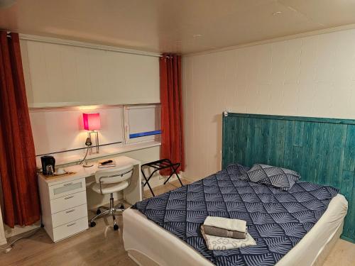 巴特斯峡湾Båtsfjord Royal Hotell的一间卧室配有一张床、一张桌子和一张桌子